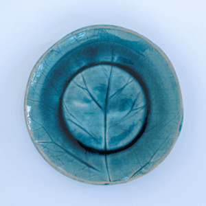 Ręcznie wykonany ceramiczny talerz, w kolorze niebieskim z motywem liścia łopianu, idealnie nada się do podania jedzenia