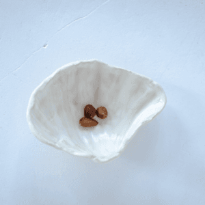 Ręcznie wykonana ceramiczna podstawka w kształcie muszelki, w kolorze białym, idealna na biżuterie