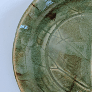 Ręcznie wykonany ceramiczny talerz, w kolorze ciemnym zielonym z motywem liścia łopianu, idealnie nada się do podania jedzenia