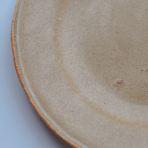 Ręcznie wykonany ceramiczny talerz, w kolorze piaskowym, idealny do podania jedzenia