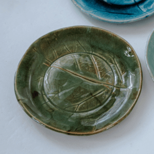 Ręcznie wykonany ceramiczny talerz, w kolorze ciemnym zielonym z motywem liścia łopianu, idealnie nada się do podania jedzenia