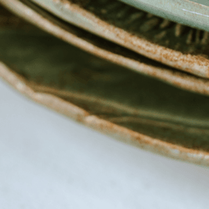Ręcznie wykonany ceramiczny talerz, w kolorze ciemnym zielonym z motywem liścia łopianu, idealnie nada się do podania jedzenia