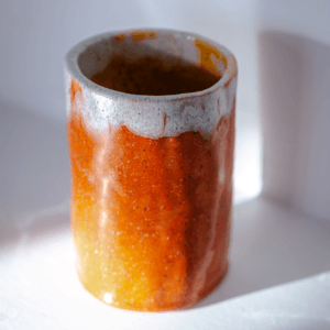 Ręcznie wykonane ceramiczne naczynie, w kolorze pomarańczowym, idealne na kwiaty