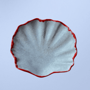 Ręcznie wykonana ceramiczna miseczka w kształcie muszelki, w kolorze szarym z czerwonym obramowaniem, idealna na biżuterie