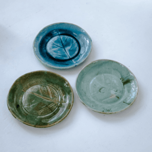 Ręcznie wykonany ceramiczny talerz, w kolorze niebieskim z motywem liścia łopianu, idealnie nada się do podania jedzenia